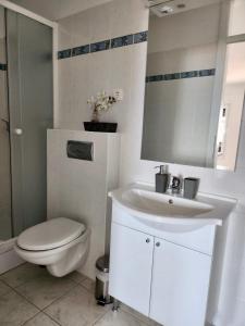 a white bathroom with a toilet and a sink at DreamWorksApartments in Karlobag