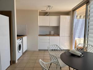 a kitchen with a table and chairs and a kitchen with a washing machine at Ocean Dream Apartment in Playa Jandia
