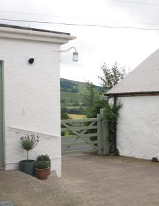 una casa bianca con un cancello e una recinzione di Willow Cottage a Dromara Altre 17 foto