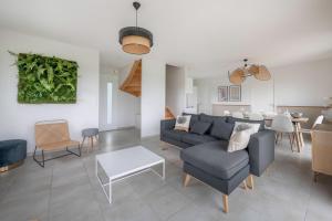 a living room with a couch and a table at À 650m du bord de mer, belle maison neuve pour 8 in Piriac-sur-Mer +12 photos