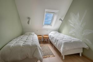 a bedroom with two beds and a window at À 650m du bord de mer, belle maison neuve pour 8 in Piriac-sur-Mer