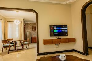 a living room with a table and a tv and a mirror at Kwetu Maili6Homes 02 in Moshi