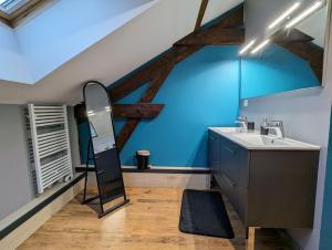 a bathroom with a sink and a blue wall at Maison Gite Le Bressaud in La Bresse +24 photos