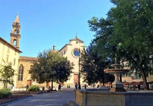 a church with a fountain in the middle of a street at San Frediano 56 in Florence