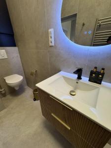 a bathroom with a white sink and a mirror at Luxury Suits Royal by Rikas Hotels in Antwerp +17 photos