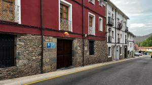 a red and white building on the side of a street at Hotel - Restaurante La Posada de Santa Rita in Enciso