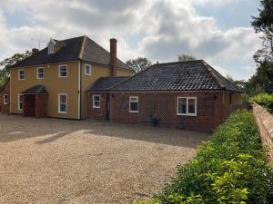 a large yellow house with a brick at Beautifully appointed & cosy self contained annexe in Walsham le Willows