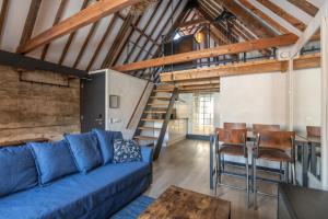 a living room with a blue couch and a table at Grapèlli Boutique Hotel in Alkmaar