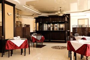 a restaurant with tables and chairs with red table cloth at Belon Life Hotel in Astana