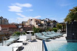 a row of white lounge chairs on a roof at Catalonia Eixample 1864 in Barcelona