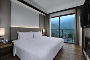 Postel nebo postele na pokoji v ubytování Grand Aston Puncak Hotel & Resort