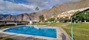 a resort swimming pool with a mountain in the background at Panoramic View Tamara Apt By Dream Homes Tenerife in Acantilado de los Gigantes