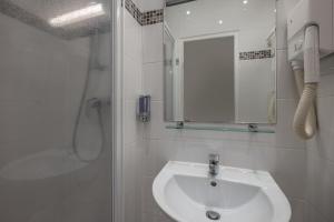 a white bathroom with a sink and a shower at Hotel la Perle Montparnasse in Paris +17 photos