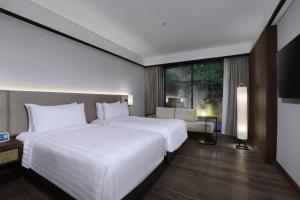 Postel nebo postele na pokoji v ubytování Grand Aston Puncak Hotel & Resort