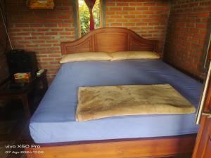 a bedroom with a bed with a wooden head board at Pondok Pengaringan Loon in Gitgit +29 photos