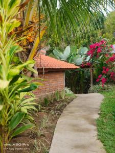 a path in a garden with flowers and a building at Pondok Pengaringan Loon in Gitgit