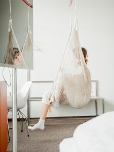 a little girl sitting in a hammock in a room at Hotel Daniel Vienna - Smart Lifestyle Near City Centre in Vienna