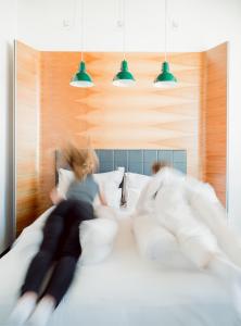 a woman laying on a bed with a man at Hotel Daniel Vienna - Smart Lifestyle Near City Centre in Vienna