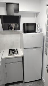 a white kitchen with a stove and a microwave at Vegas luxury apartment in Constanţa