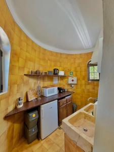 a kitchen with a counter and a sink and a tub at O Moinho de Vale da Mó in Anadia +24 photos