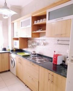 eine Küche mit Holzschränken und einem Herd mit Backofen in der Unterkunft Amwaj North Cost VIP Chalet in El-Alamein + 16 Fotos