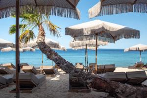 a beach with chairs and umbrellas and the ocean at Oniro Boutique Hotel in Toroni