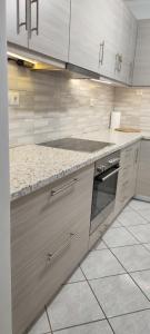 a kitchen with white cabinets and a stove top oven at aggelos home in Kato Alepochori