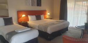 a hotel room with two beds and a chair at Suite 26 - Town Central - Walk To Cafes - Sleeps 3 in Margaret River Town