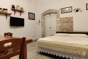 a bedroom with a bed and a table and a television at A casa di Gino in Molfetta