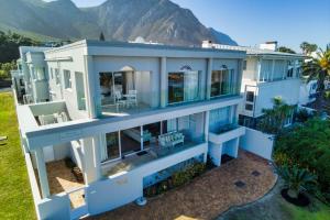 an aerial view of a house with mountains in the background at Hermanus Beachfront Lodge in Hermanus