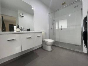 a white bathroom with a toilet and a glass shower at Spacious 4 Bed Family Home in Christchurch +47 photos