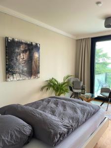 a bedroom with a bed with a painting on the wall at Huus Bellevue in Gleisweiler