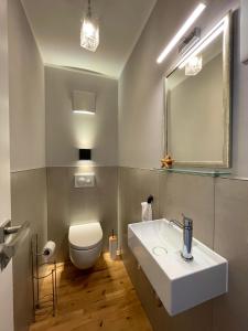a bathroom with a white sink and a toilet at Huus Bellevue in Gleisweiler