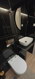 ein Badezimmer mit weißer Toilette und Spiegel in der Unterkunft Ina's Crib in Síndos + 20 Fotos