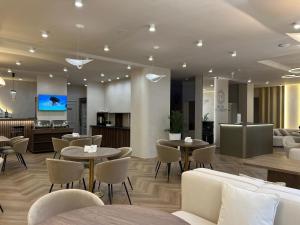 a restaurant with tables and chairs and a kitchen at Hotel FN Shymkent in Shymkent