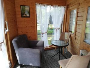 a room with a chair and a table and a window at Sommerferienhaus Jeannette in Strausberg