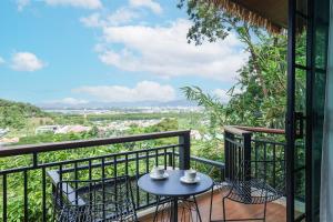 a balcony with a table and chairs and a view at Pha Lae Tawan@Siray in Phuket