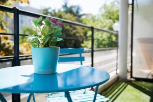 a blue table with a potted plant on a balcony at Chez Fany - Superbe appartement en résidence avec parking in Metz