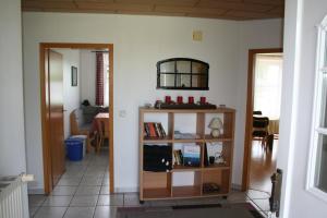 a living room with a book shelf and a table at Ferienwohnung Ehmsen in Groß Vollstedt