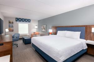 a hotel room with a bed and a desk at Hampton Inn & Suites Charlottesville at the University in Charlottesville +34 photos