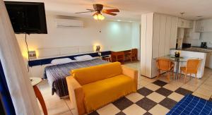 a living room with a bed and a yellow couch at Flat no Iate Plaza Hotel in Fortaleza