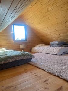 two beds in a room with a wooden ceiling at Zielona Chatka in Augustów