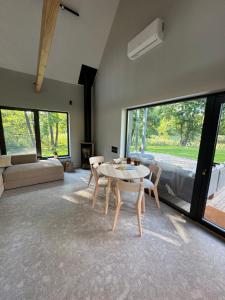 a living room with a table and chairs and a couch at Lavender Resort in Molėtai