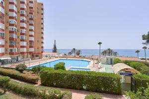 a swimming pool in front of a large building at Primera línea con terraza A104 in Torrox