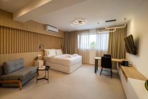 Una habitación de hotel con una cama, un sofá y una silla. en Eria Suites Thessaloniki, en Tesalónica
