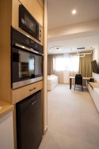 Una cocina con microondas y una sala de estar. en Eria Suites Thessaloniki, en Tesalónica