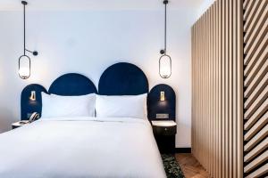 a bedroom with a large bed with a blue headboard at Doubletree By Hilton Nice Centre Iconic in Nice