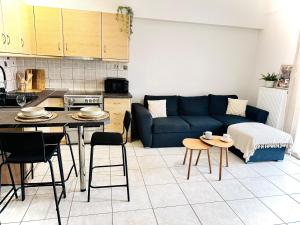 a living room with a blue couch and a table at Gemütliche Wohnung mit Balkon in Orestiada