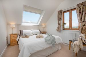 a bedroom with a large white bed with towels on it at Long Meadow Barn in Crediton