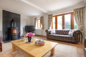 a living room with a couch and a table at Long Meadow Barn in Crediton